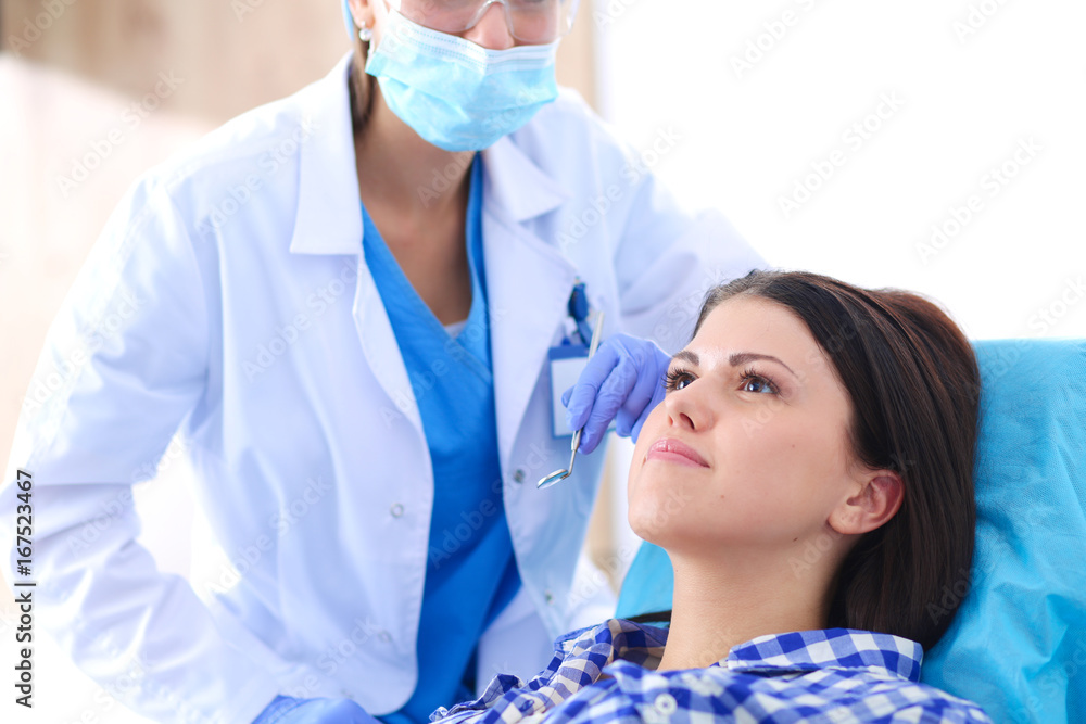Woman dentist working at her patients teeth