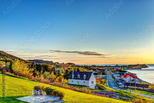 Hotel chairs on hill during sunrise in Perce, Gaspe Peninsula, Quebec, Canada, Gaspesie region with cityscape photo
