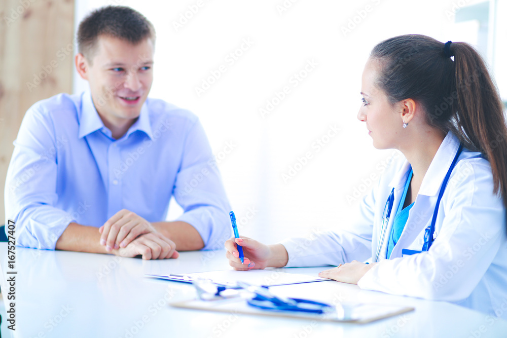 Doctor woman sitting with male patient at the desk Doctor woman sitting with male patient at the desk