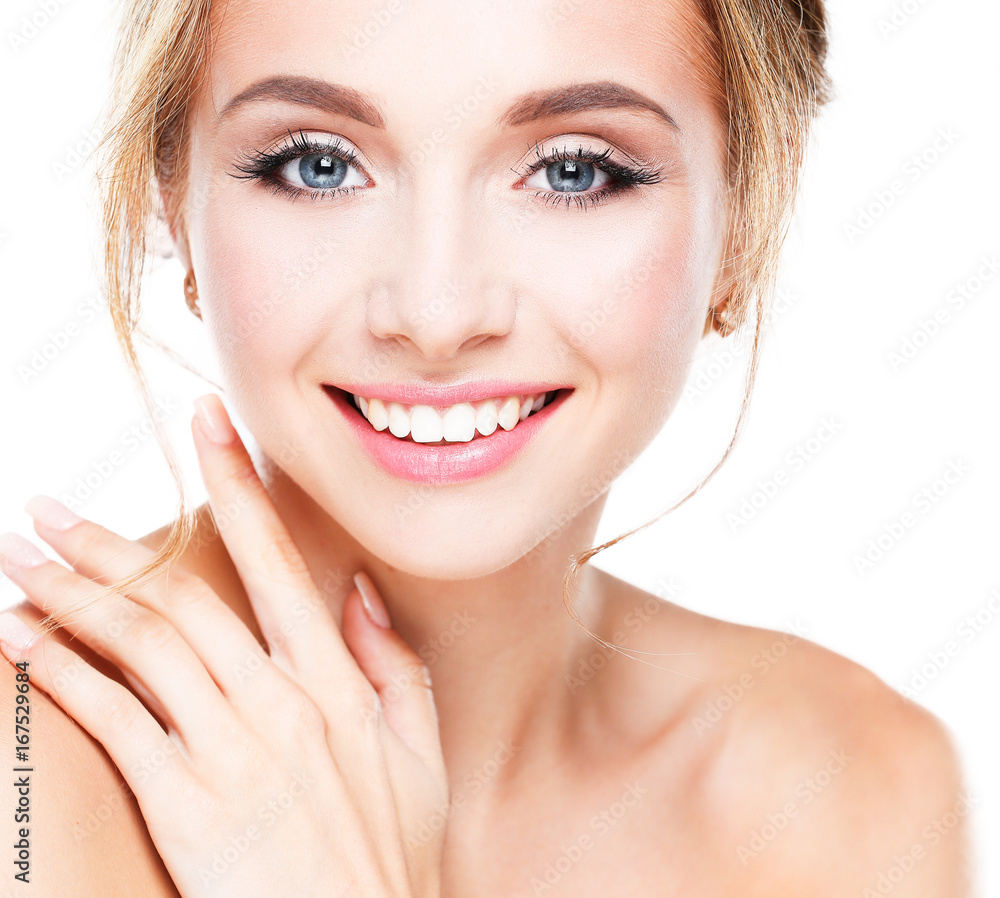 Studio shot of a beautiful young woman with perfect skin against a gray background.