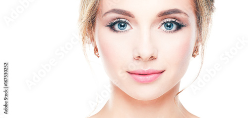 Studio shot of a beautiful young woman with perfect skin against a gray background.