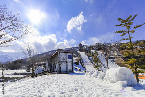 Ski jump area or ski springboards against with snow on the mountain and blue sky and clouds background in Hakuba  Nagano Japan.