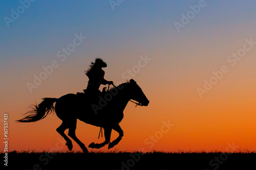 Sillouette of a Cowgirl on Horseback photo