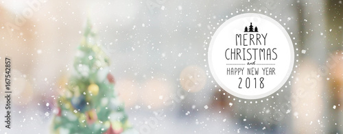 Christmas and Happy new year 2018 on blurred bokeh christmas tree with snowfall banner background photo