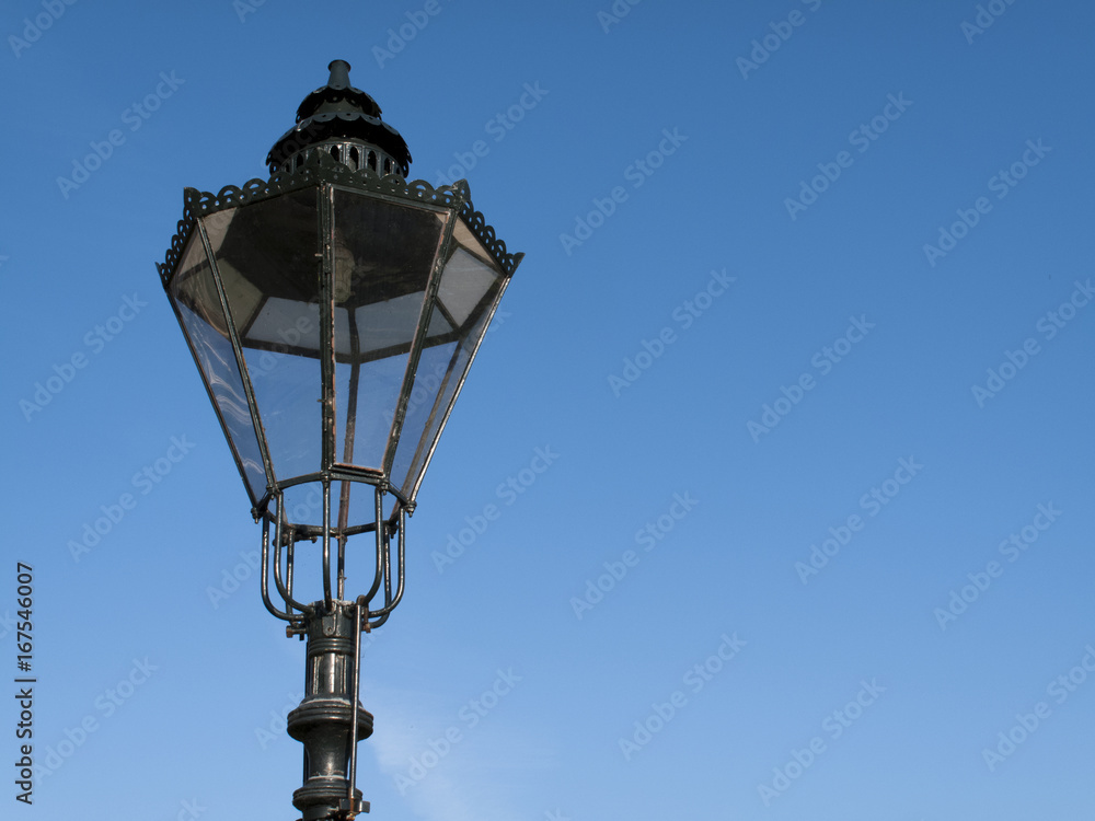 Period styled cast iron streetlamp against a clear blue sky