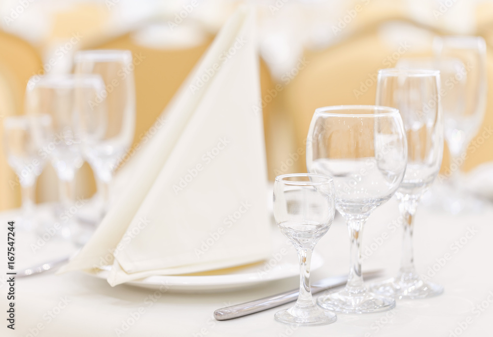 A set table in the restaurant with empty glasses and cutlery decorated with napkins. A set table in the restaurant with empty glasses and cutlery decorated with napkins.