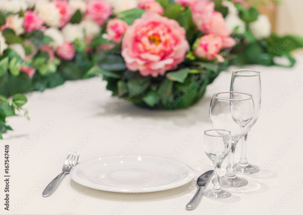 Served table for one person with a set of glasses, decorated with natural flowers. Event dinner Served table for one person with a set of glasses, decorated with natural flowers. Event dinner