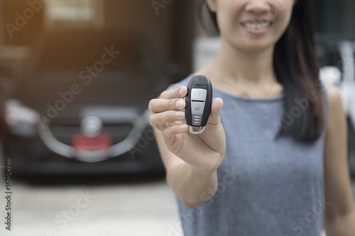 Woman holds new car show keys. The rear is a new vehicle.Concept finance.Car business concept.