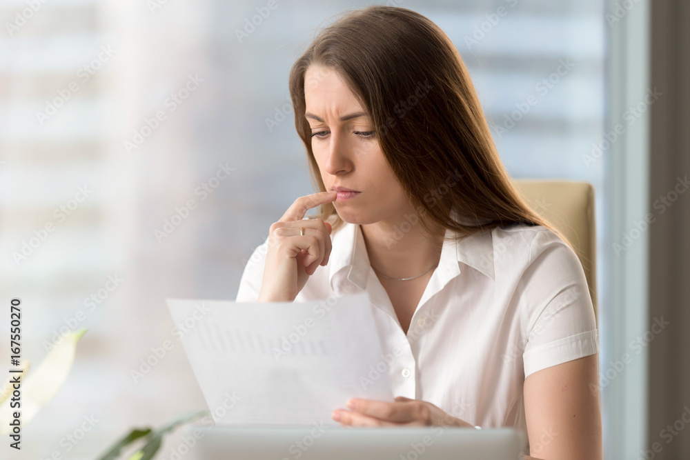 Serious thoughtful businesswoman analyzing important document, focused analyst scrutinizing report, examining company development, thinking of stats result, reading financial statement, head shot Serious thoughtful businesswoman analyzing important document, focused analyst scrutinizing report, examining company development, thinking of stats result, reading financial statement, head shot