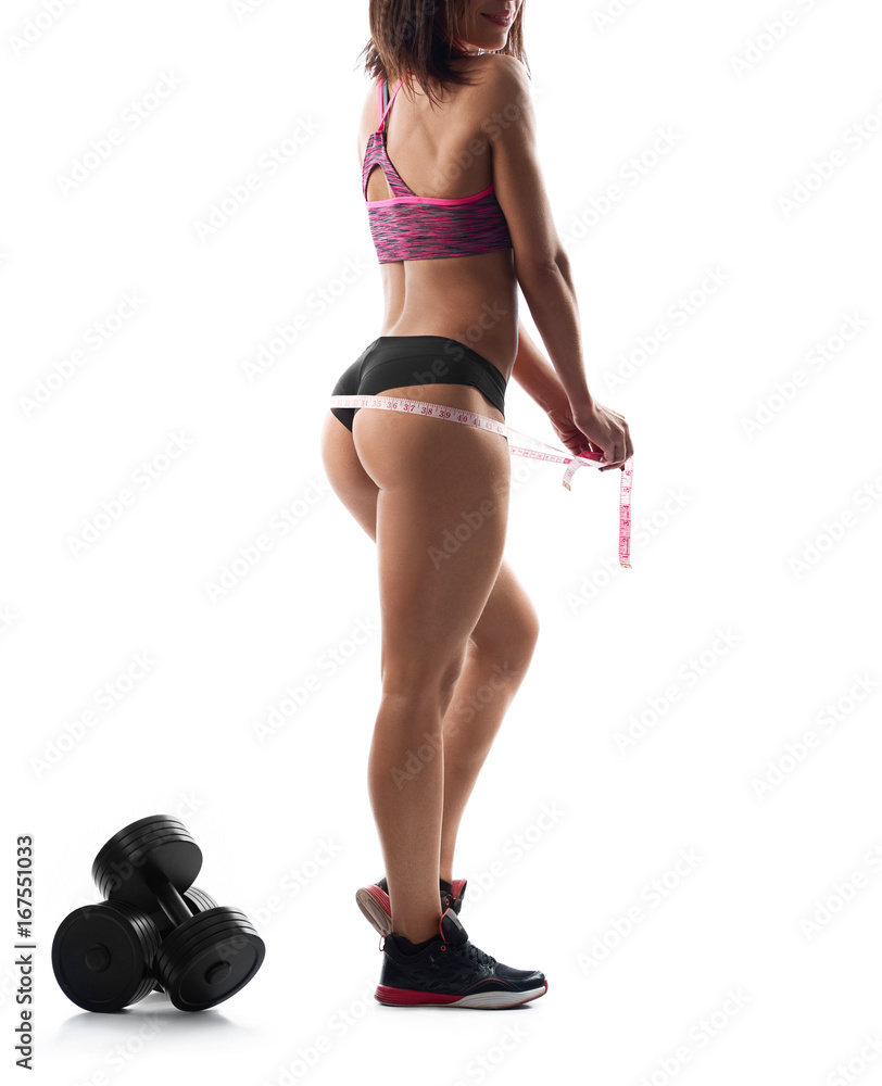Cropped rearview shot of a sexy sporty woman wearing sports top and shorts posing isolated on white measuring her hips showing off her perfectly shaped toned buttocks. Cropped rearview shot of a sexy sporty woman wearing sports top and shorts posing isolated on white measuring her hips showing off her perfectly shaped toned buttocks.