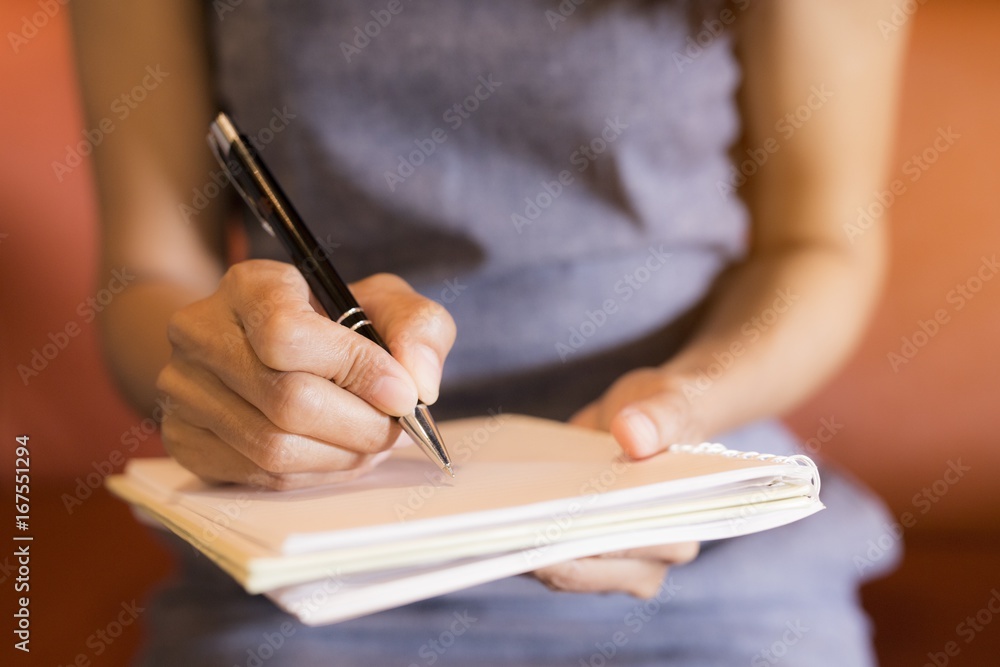 Women holding a pens writing a notebook. Recording concept Women holding a pens writing a notebook. Recording concept