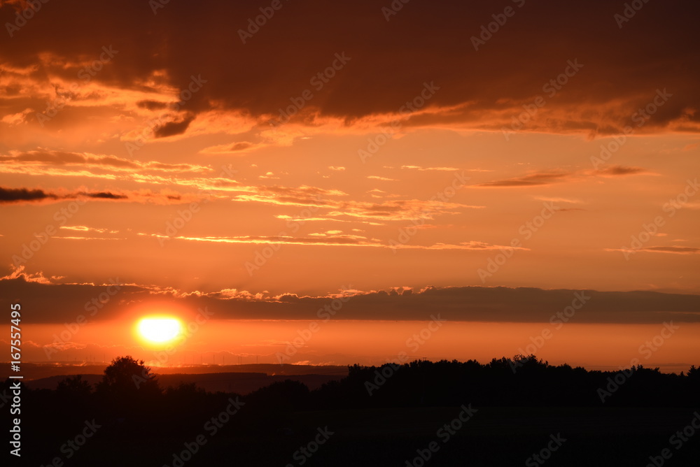 Sonnenuntergang mit kräftigenund intensiven Abendrot mit Windrädern im Hintergrund