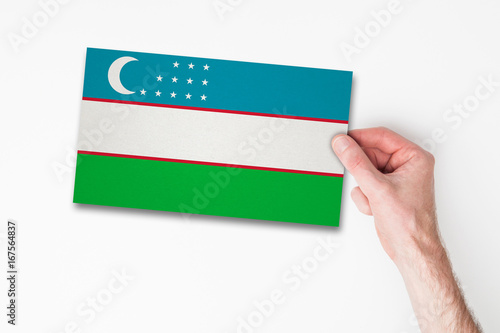 Male hand holding uzbekistan flag