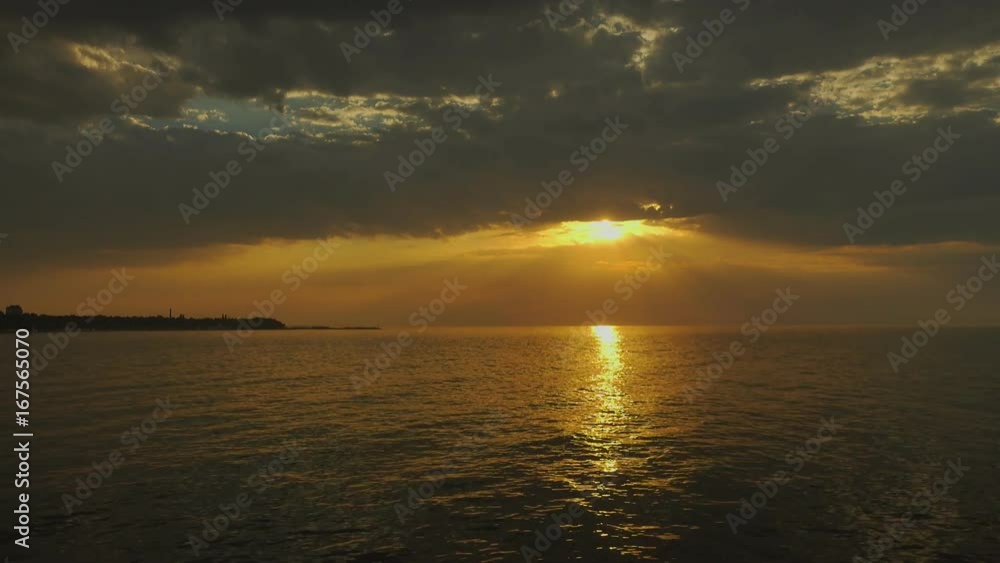 Sunset over the sea with sun rays and dramatic clouds Sunset over the sea with sun rays and dramatic clouds