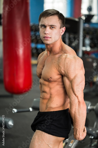 detail of a bodybuilder posing in the gym: side chest