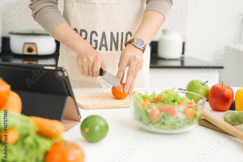 Handsome asian man chopping vegetables in the kitchen