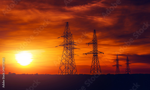 High-voltage power lines at sunset. Electricity distribution station.