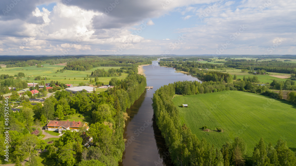 Aerial view of a green field from and river