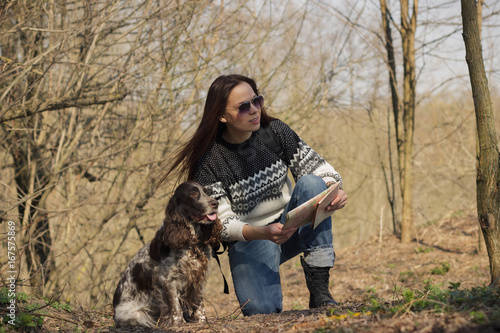Beautiful woman brunette and brown cocker spaniel in the forest