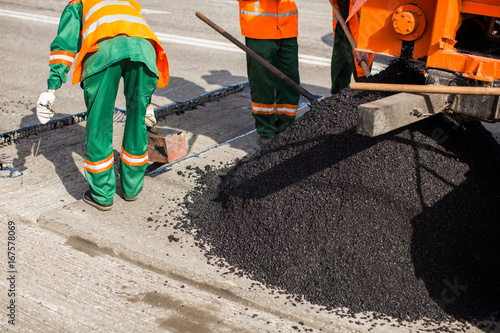 The man working asphalt pouring tar for road repair