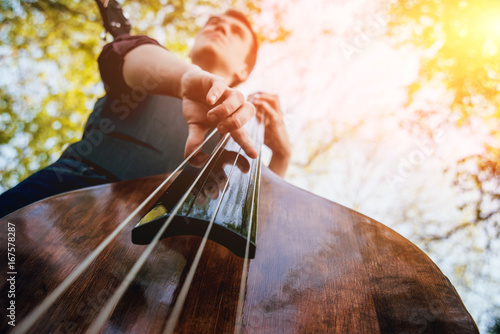View of musician playing contrabass at the street. Musical Instrument photo