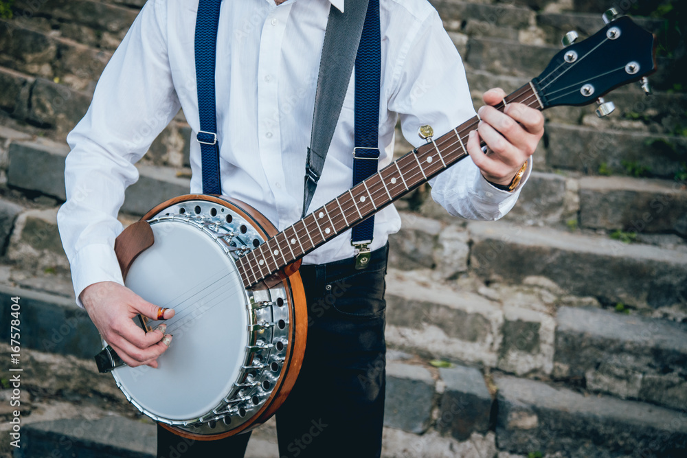 Fototapeta View of musician playing banjo at the street