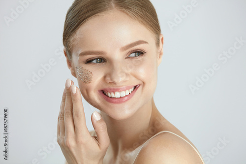 фотографія Face Skin Scrub. Smiling Female Applying Scrub On Face Skin