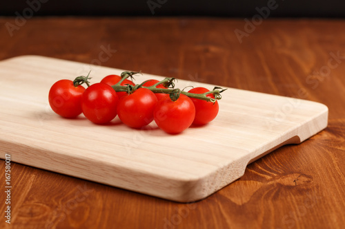 small cherry tomatos on wooden cutting board