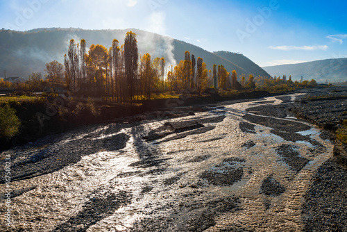 Fast mountain river in bright sunlight, autumn landscape