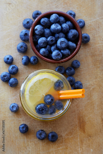 Fresh made lemon Juice drink with blueberries on wooden background