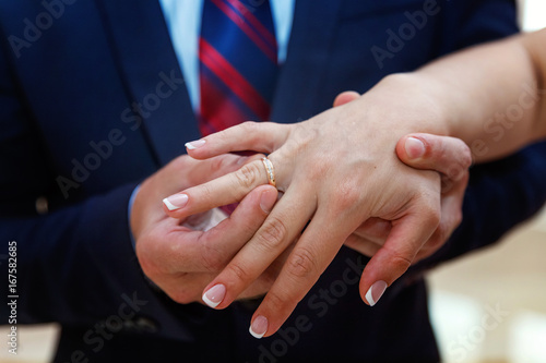the groom wears a ring on the bride's