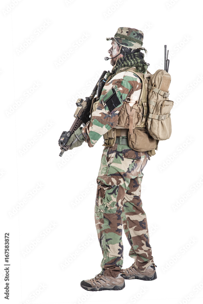Special forces United States in Camouflage Uniforms studio shot. Holding weapons, wearing jungle hat, Shemagh scarf, painted face, his outfit clothes designed for jungle warfare. Studio shot isolated Special forces United States in Camouflage Uniforms studio shot. Holding weapons, wearing jungle hat, Shemagh scarf, painted face, his outfit clothes designed for jungle warfare. Studio shot isolated