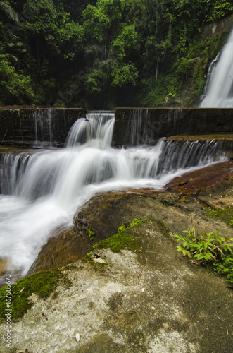 Beautiful in nature landscape, waterfall stream surrounded by green tropical green forest