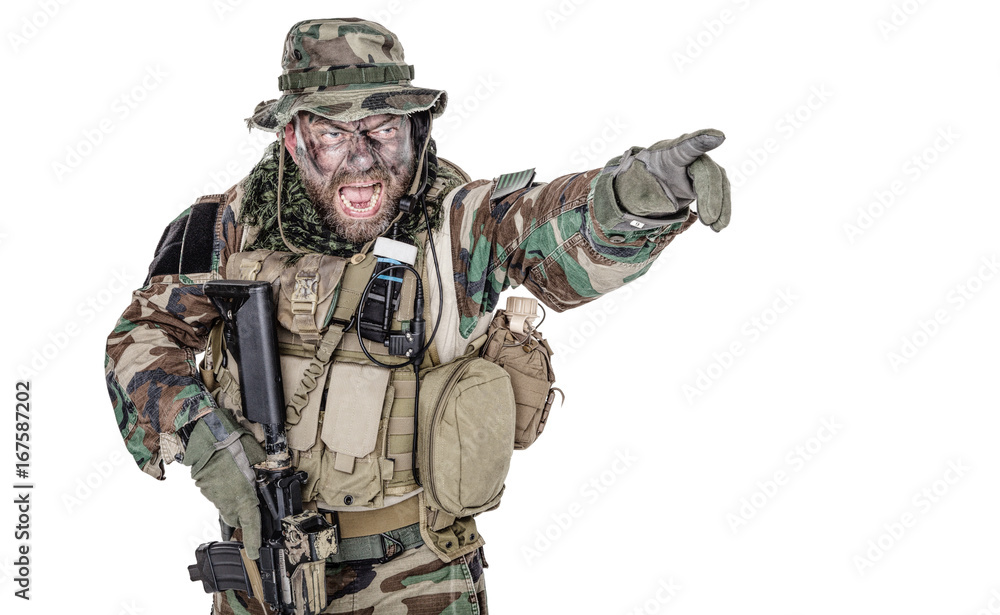 United States Commando half length studio shot. Mouth opened, soldier yelling, emitting intiminate formidable frightening scream pointing finger target and giving attack direction to subordinates United States Commando half length studio shot. Mouth opened, soldier yelling, emitting intiminate formidable frightening scream pointing finger target and giving attack direction to subordinates
