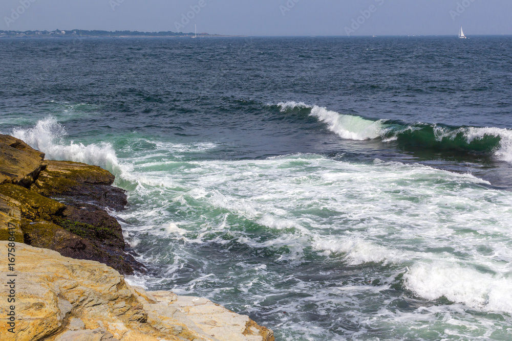 Waves crashing into shoreline on a summer day