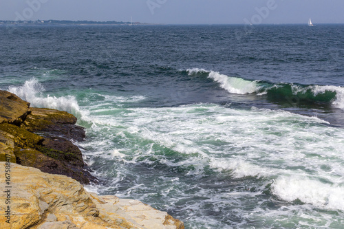 Waves crashing into shoreline on a summer day