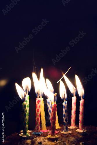 Burning festive candles on a cake surface. Festive background