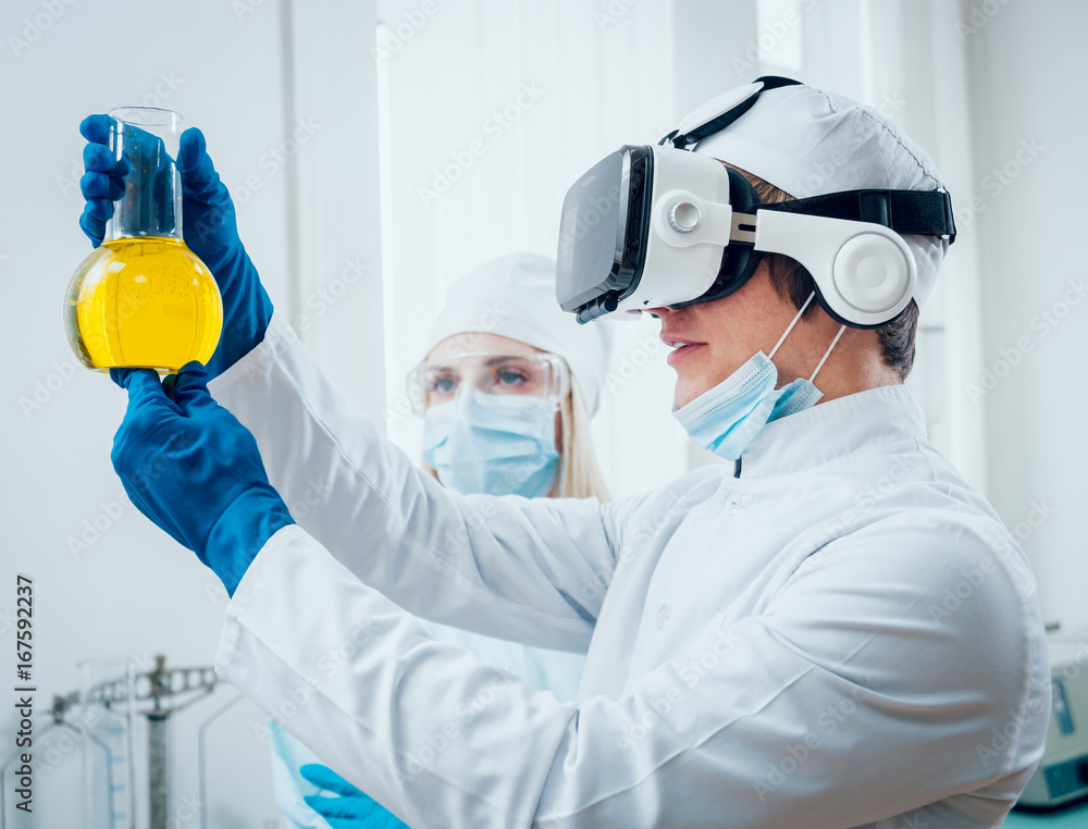 Doctor in virtual reality glasses examines the drug in laboratory. Doctor in virtual reality glasses examines the drug in laboratory.