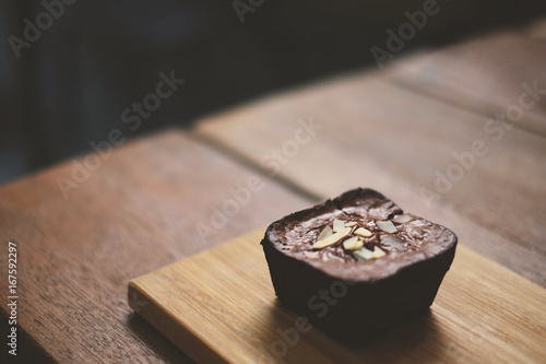 Soft focus Brownie dark chocolate topping with almond on the wood table