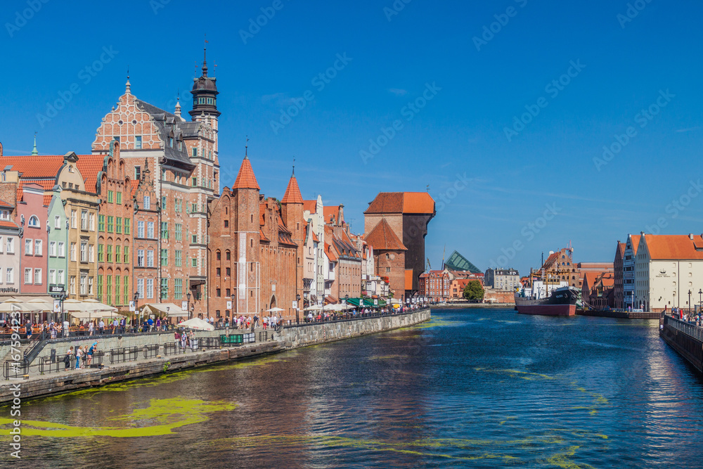 Obraz premium GDANSK, POLAND - SEPTEMBER 1, 2016: Riverside houses by Motlawa river in Gdansk, Poland. Medieval crane in the background.