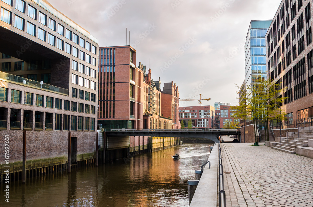 Old and Modern Buildings alongside a Canal in Hamburg at Sunset.