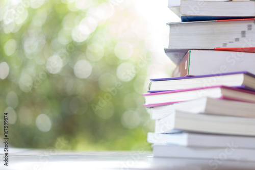 stack of books with green bokeh background