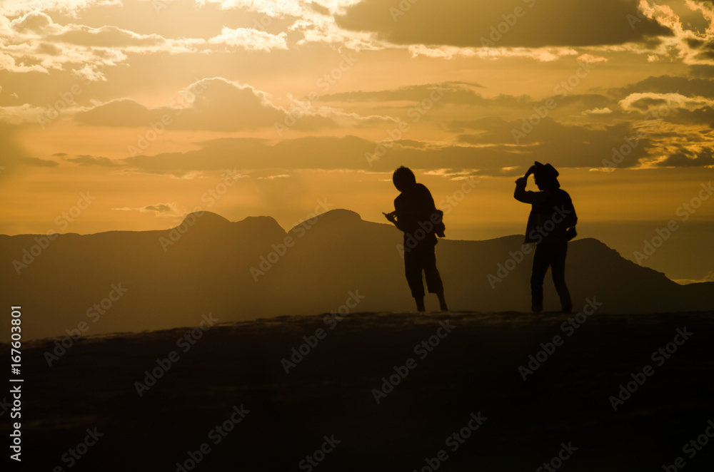 Silhouettes of two people walking on White Sand Dunes during sunset in New Mexico