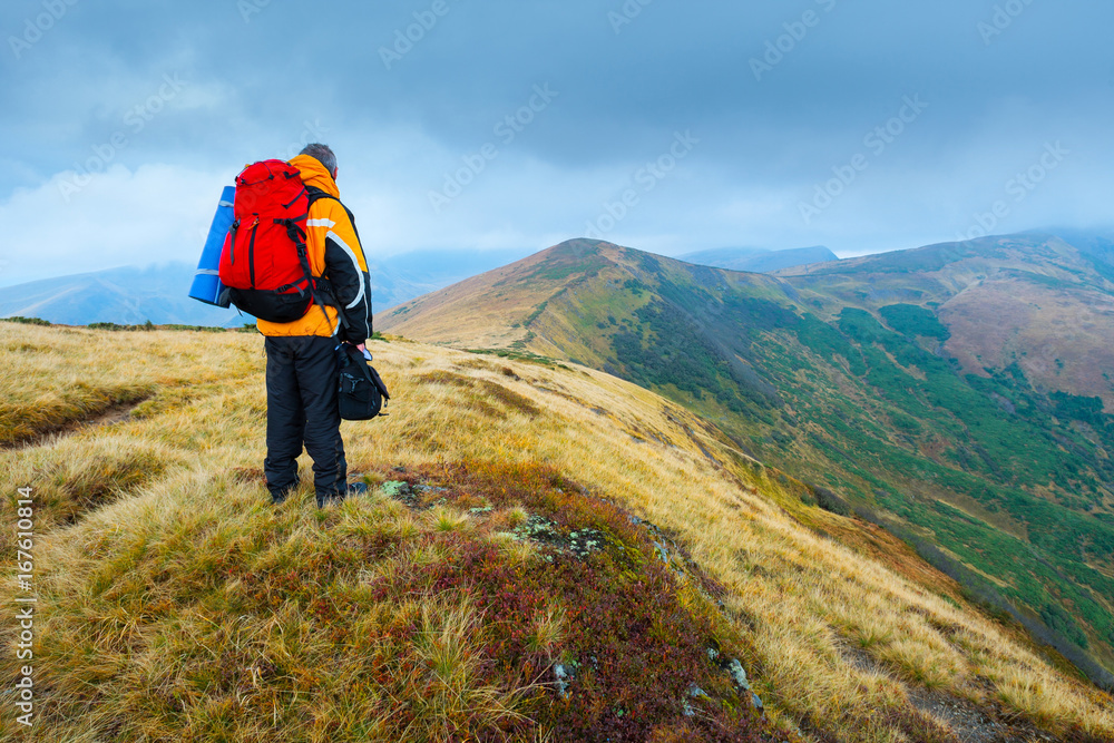 Hiking tourists with backpacks in the mountains. Climb to the top mountains. Concept theme: nature, weather, mountain climbing, tourism, extreme, healthy lifestyle, adventures. Unrecognizable faces.