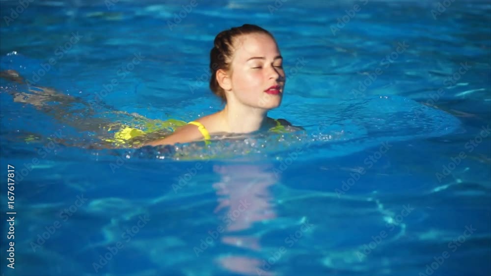 Young beauty swim in the swimming pool and smiling. Beautiful woman with make up in water Young beauty swim in the swimming pool and smiling. Beautiful woman with make up in water