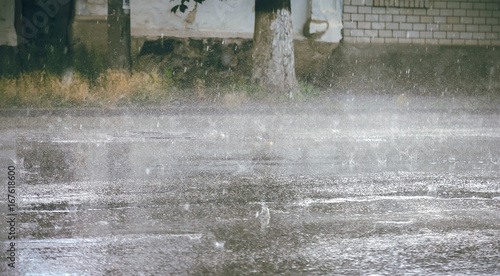 heavy rain drops falling on city street