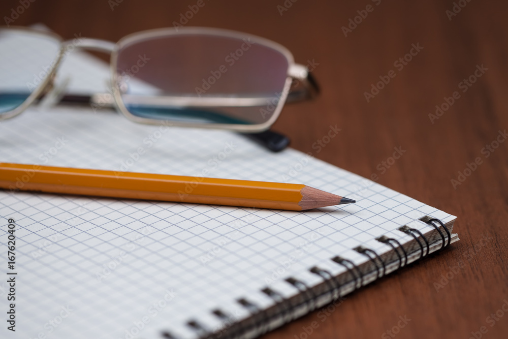 Fototapeta premium Eye glasses with pencil and binder notebook