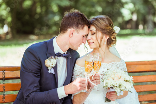 Groom and bride sits in the park photo