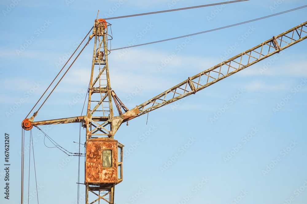 Cabin of old abandoned rusty tower crane on a blue sky background Cabin of old abandoned rusty tower crane on a blue sky background