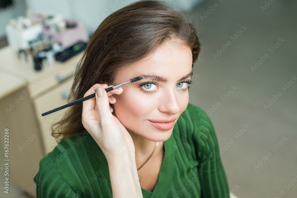 Woman paints the eyebrows